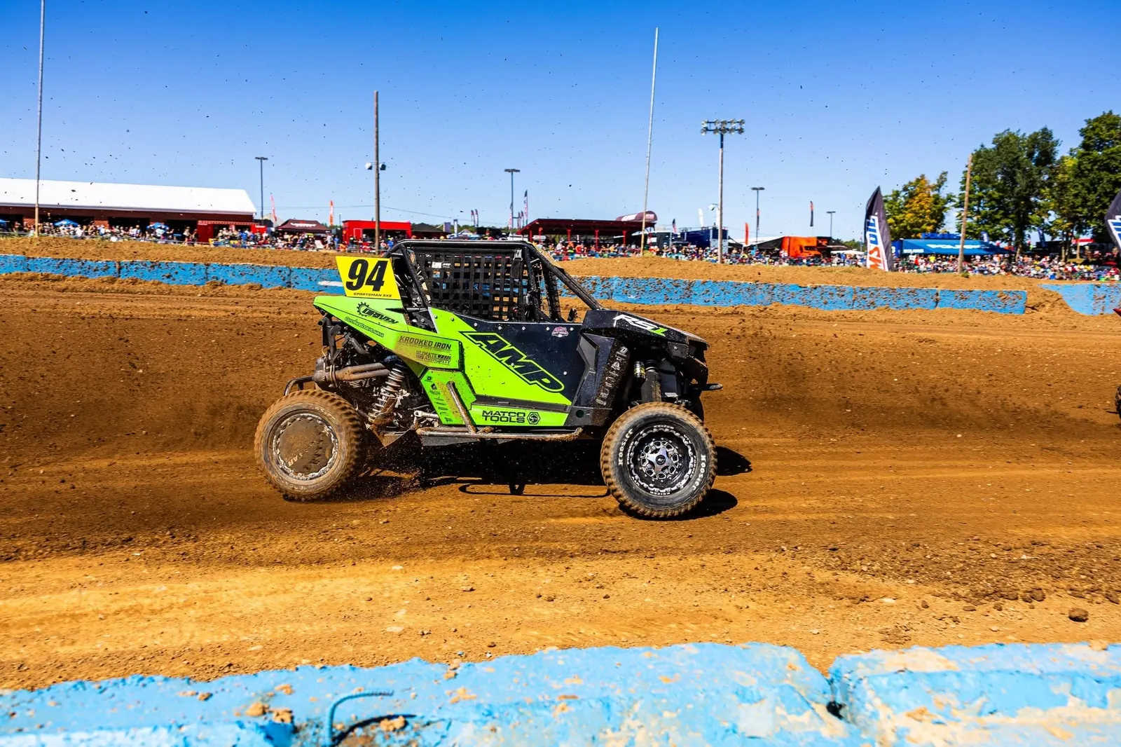 Lime #94 race side-by-side powering out of a dirt-track corner