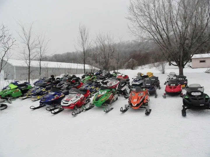 Dozens of snowmobiles lined up on a winter group ride