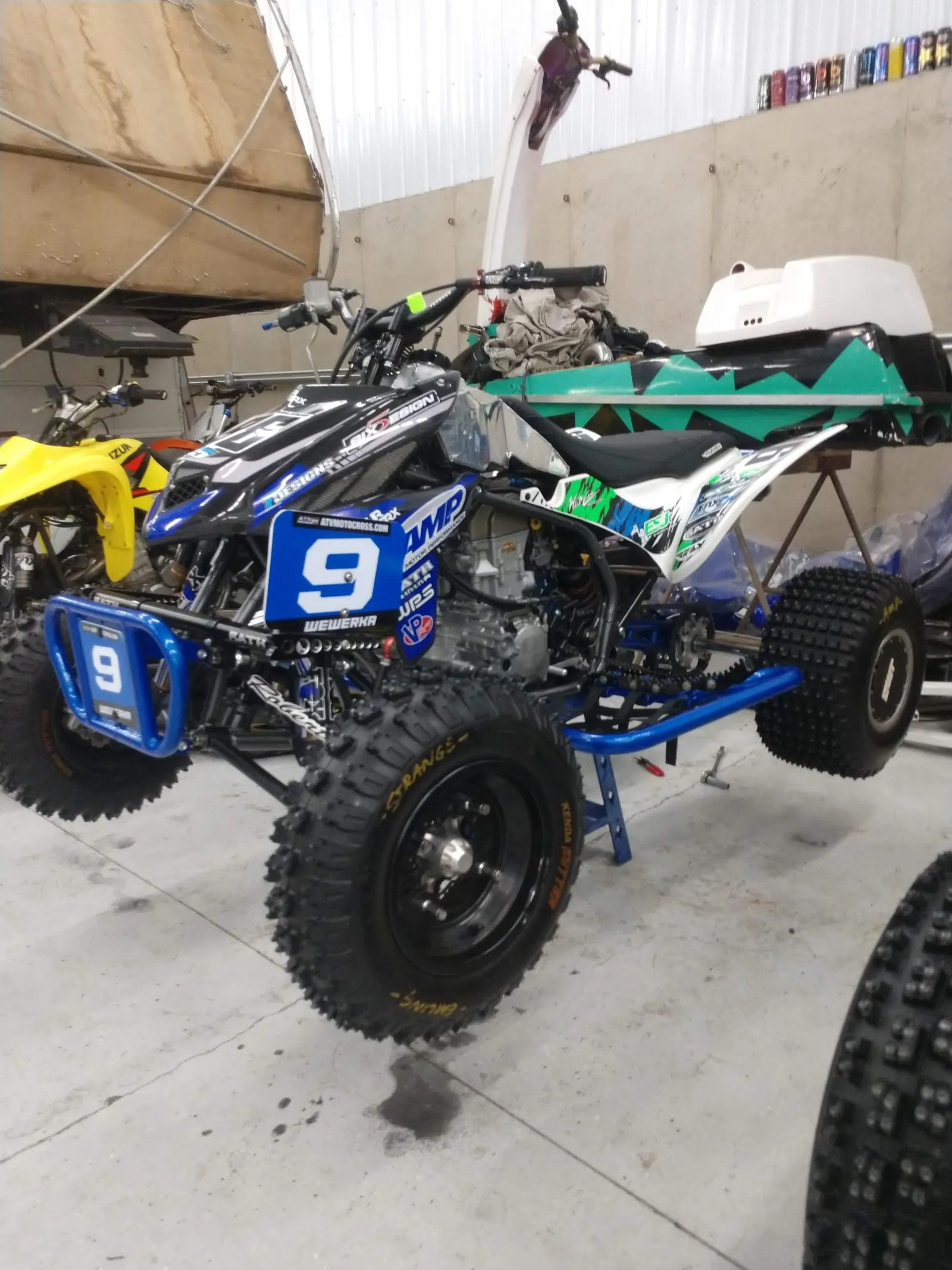 AMP-sponsored race quad with number 9 plate in the shop