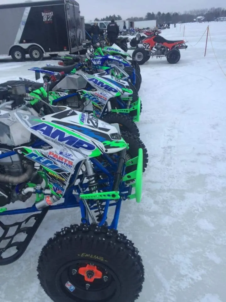 AMP-branded race quads lined up on snow