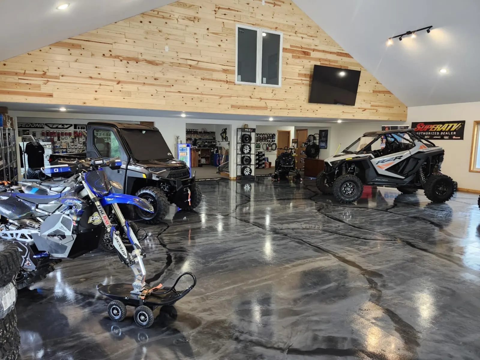 Showroom with side-by-sides, a dirt bike and a polished epoxy floor