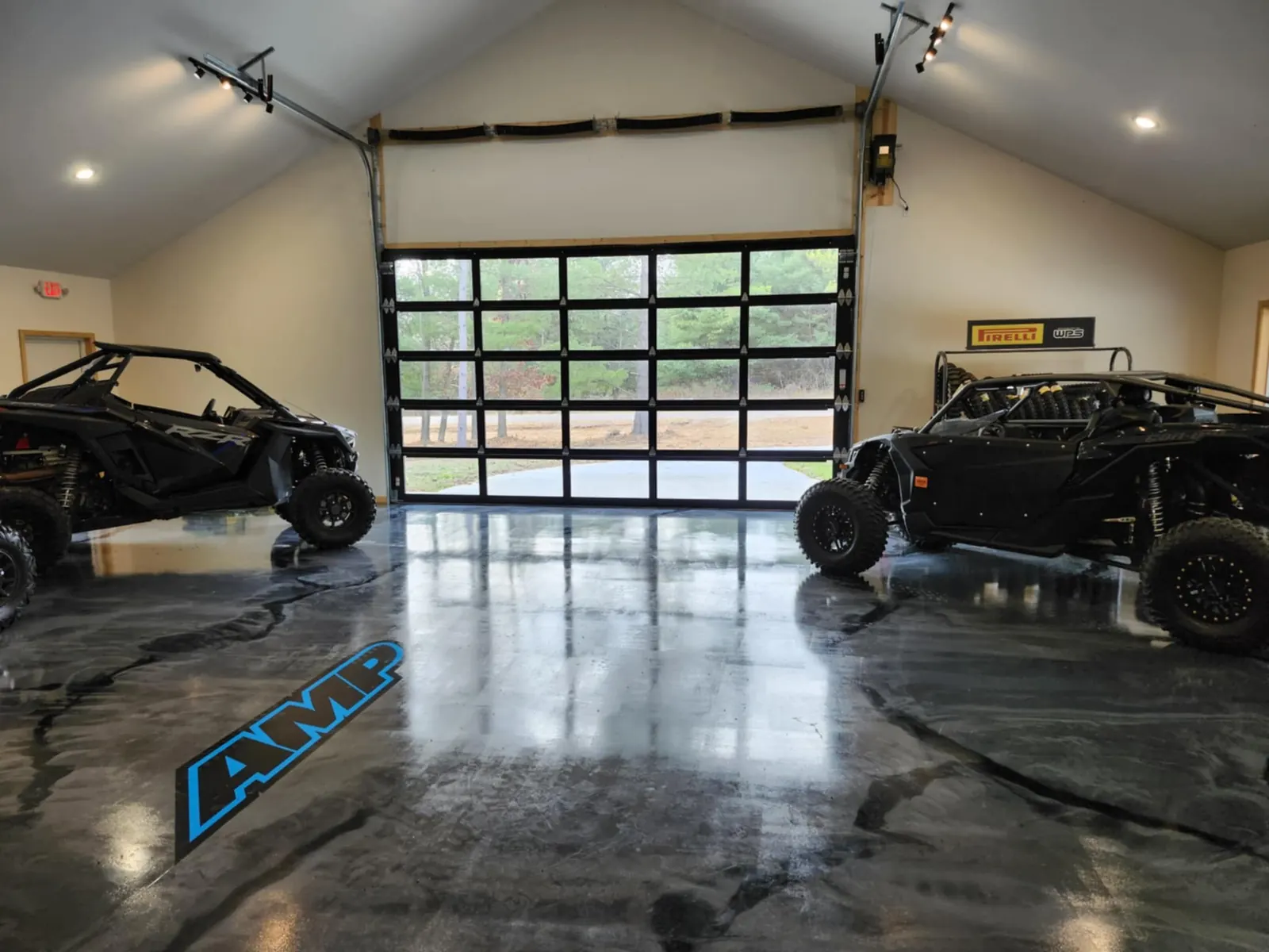 Two sport side-by-sides by the glass overhead door in the showroom